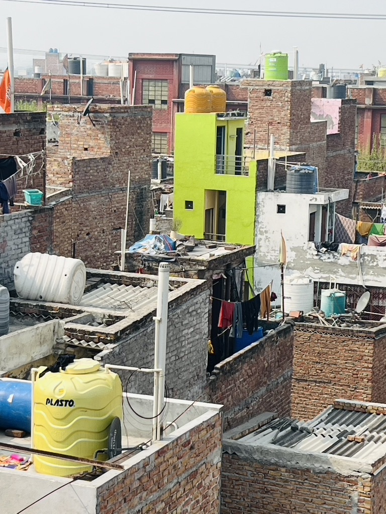 Water storage Tanks on rooftops. Savda, 2025. Patients & Families waiting for treatment at the entrance of a Big Hospital, New Delhi 2002. Alt text