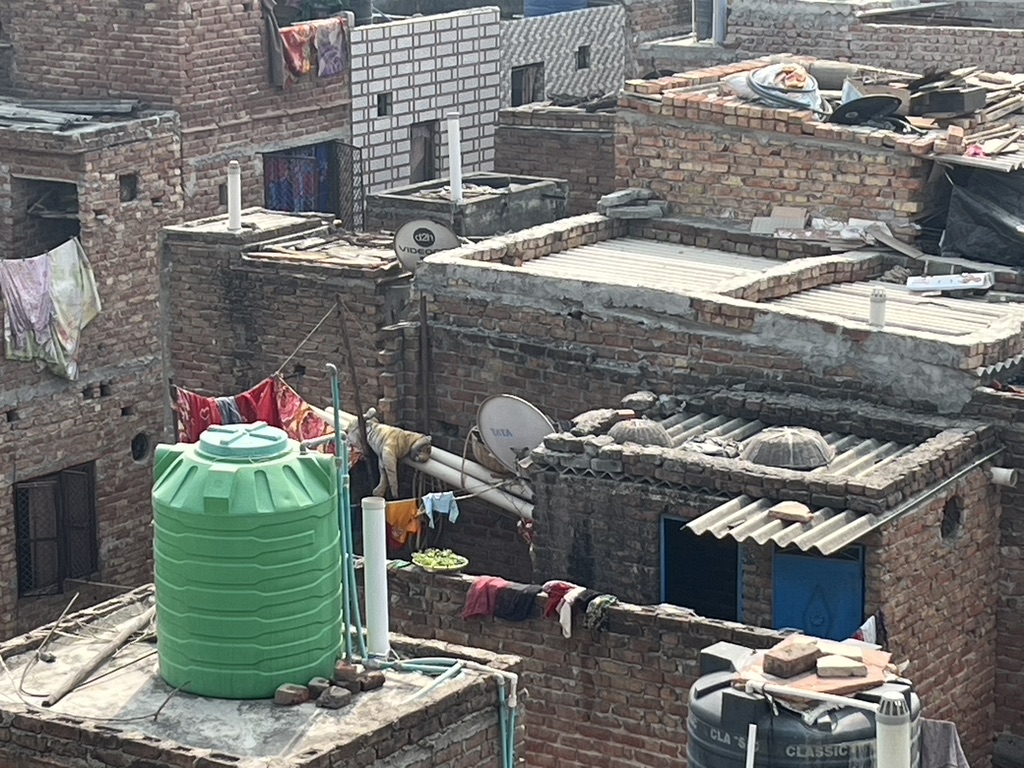 A water storage tank on the roof at Savda, 2025. Waiting_Bedding piled up of Patients & Families in the corridors of a 'Big Hospital'_New Delhi 2002. Photo: Kavita Dasgupta